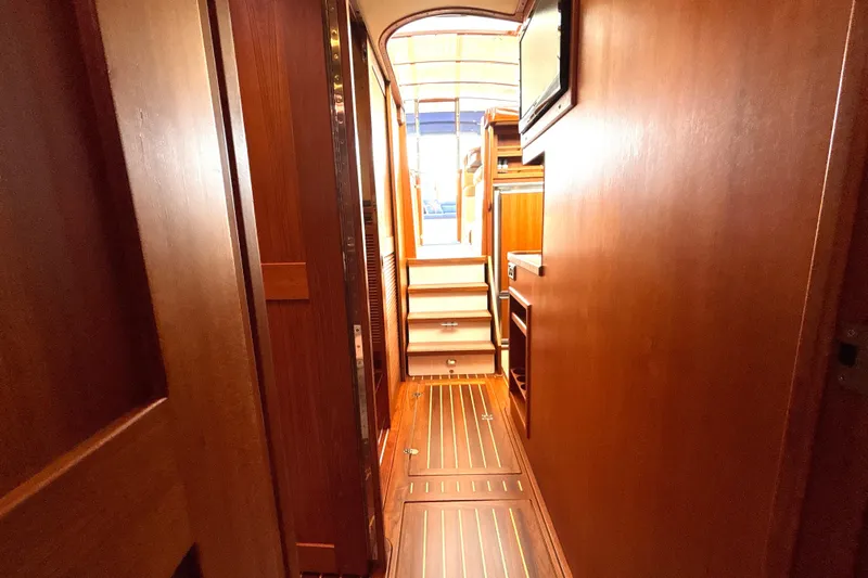 Flight Yacht Photos Pics Interior hallway of 2009 San Juan 48 yacht with wooden finishes and steps.