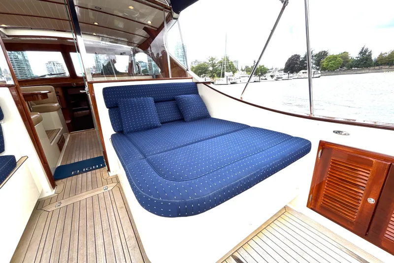 Flight Yacht Photos Pics Luxurious 2009 San Juan 48 yacht with blue cushioned seating and elegant wooden interior.