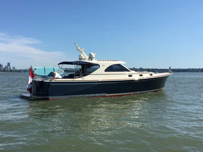 Flight Yacht Photos Pics 2009 San Juan 48 yacht on calm water with city skyline in background.