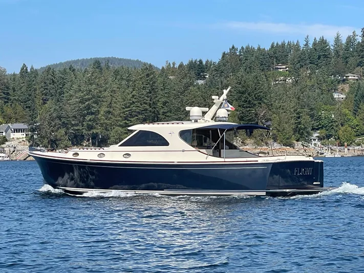 Flight Yacht Photos Pics 2009 San Juan 48 yacht cruising on a scenic lake with forested hills in the background.