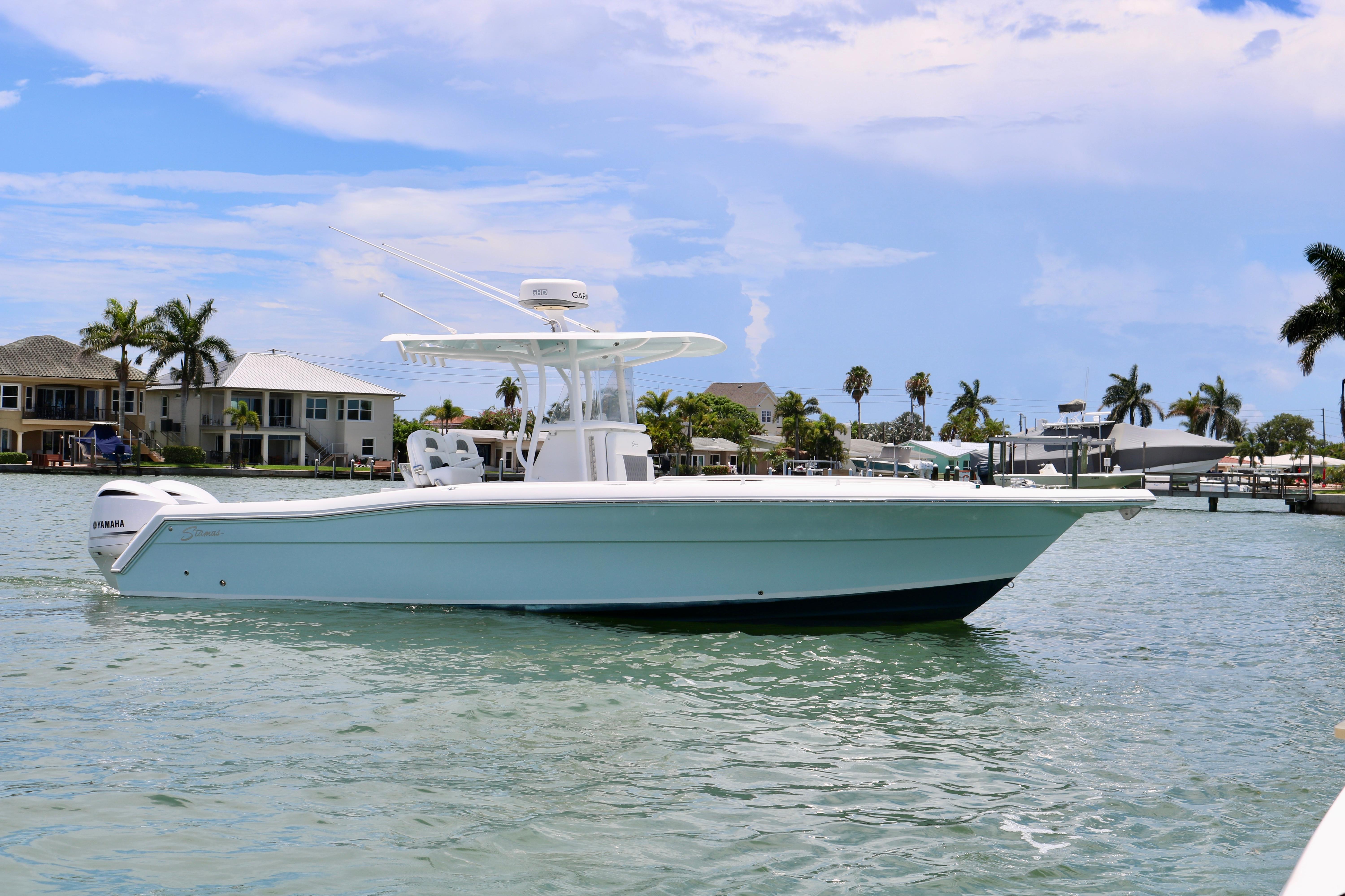 2016 Stamas 317 Tarpon boat cruising on a sunny day near waterfront homes.