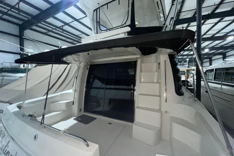  Yacht Photos Pics 2004 Carver 460 Voyager yacht in indoor storage, rear view with steps and canopy.
