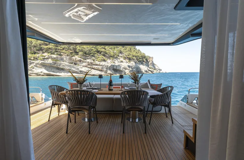 Orca I Yacht Photos Pics Luxurious 2022 Cranchi Settantotto 78 yacht deck with elegant dining area and scenic ocean view.