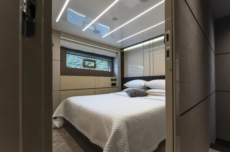 Orca I Yacht Photos Pics Luxurious bedroom interior of 2022 Cranchi Settantotto 78 yacht with modern design and cozy bedding.
