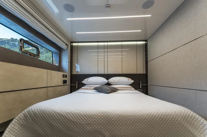 Orca I Yacht Photos Pics Luxurious bedroom interior of 2022 Cranchi Settantotto 78 yacht with modern design and cozy bedding.