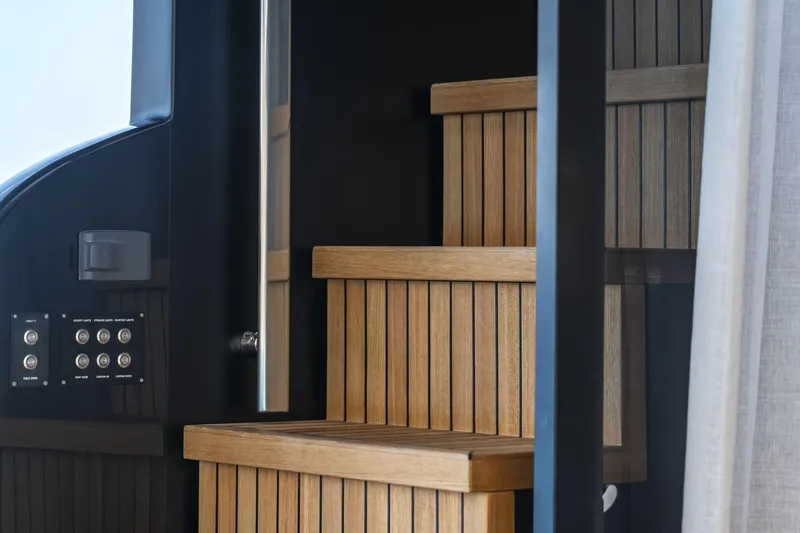 Orca I Yacht Photos Pics Wooden staircase inside 2022 Cranchi Settantotto 78 yacht, featuring sleek design and control panel.