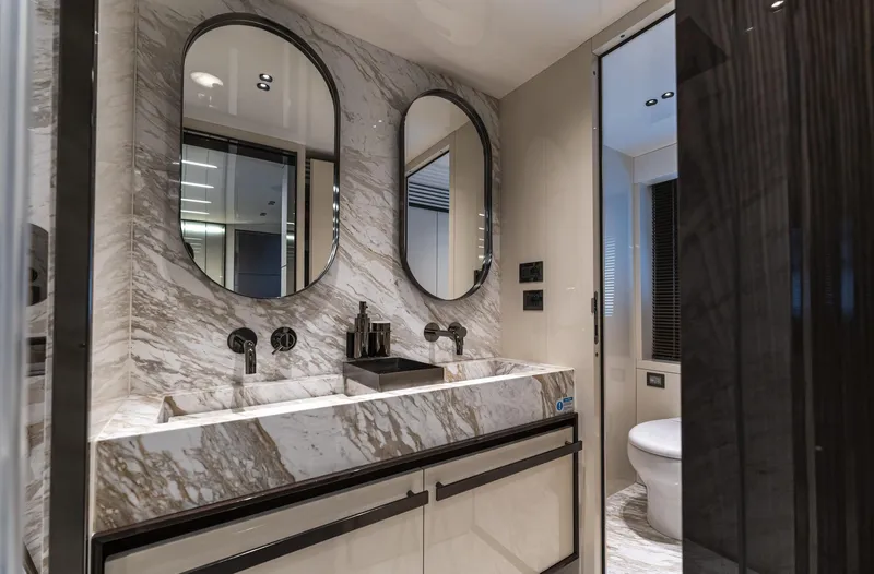 Orca I Yacht Photos Pics Luxurious bathroom in 2022 Cranchi Settantotto 78 yacht with marble finishes and dual mirrors.