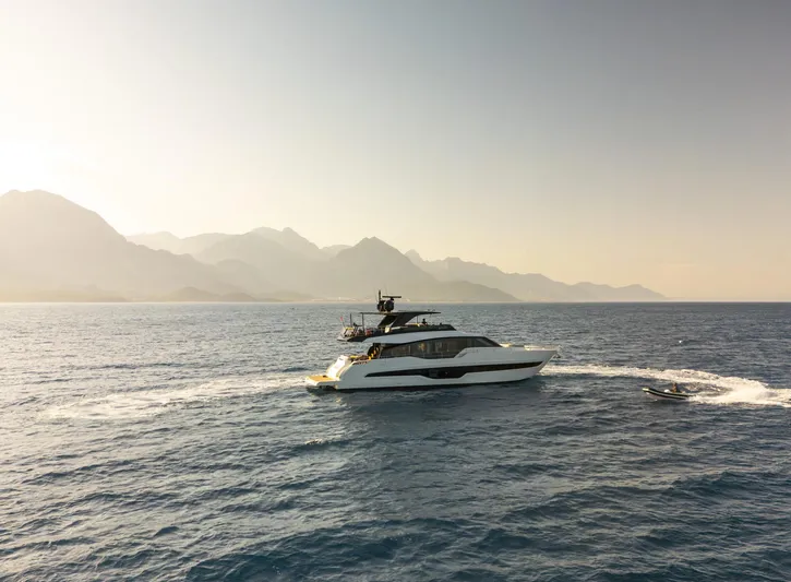 Orca I Yacht Photos Pics 2022 Cranchi Settantotto 78 yacht cruising on serene waters with mountainous backdrop.