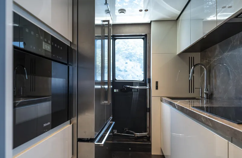 Orca I Yacht Photos Pics Modern kitchen interior of 2022 Cranchi Settantotto 78 yacht, featuring sleek appliances and elegant design.