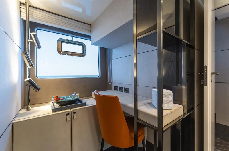 Orca I Yacht Photos Pics 2022 Cranchi Settantotto 78 yacht interior with modern desk, orange chair, and window view.