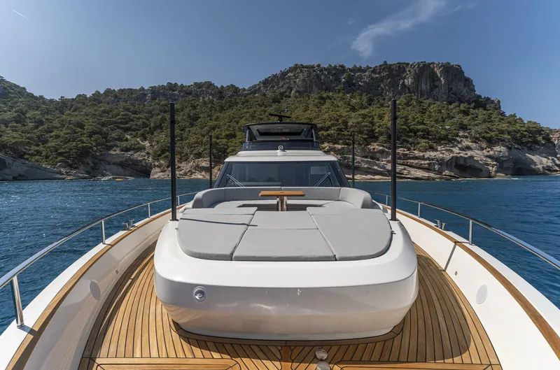 Orca I Yacht Photos Pics 2022 Cranchi Settantotto 78 yacht on serene blue waters with scenic rocky backdrop.