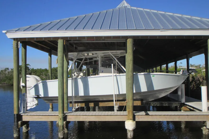  Yacht Photos Pics 2012 Jupiter 30 FS boat docked under a covered boathouse on a sunny day.