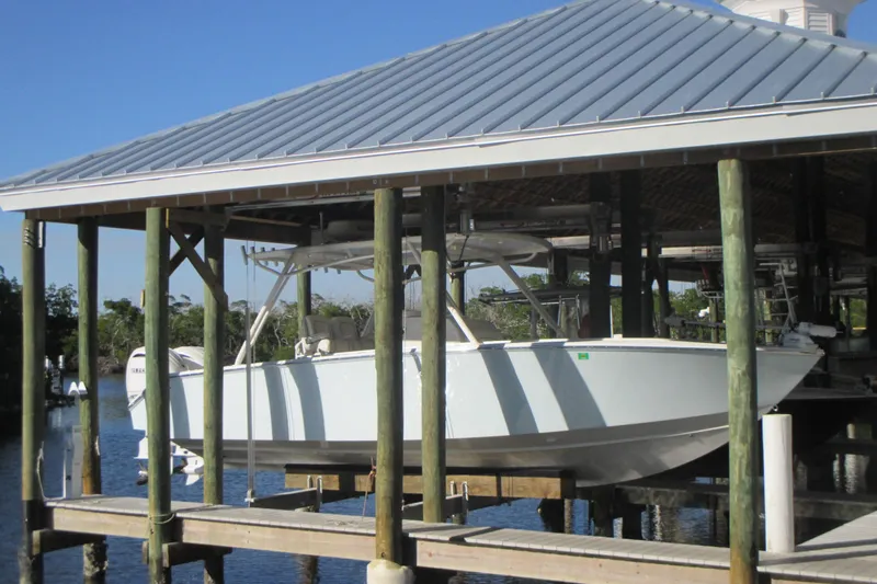  Yacht Photos Pics 2012 Jupiter 30 FS boat docked under a covered structure on a sunny day.