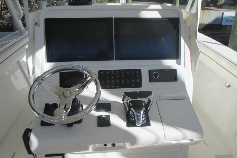  Yacht Photos Pics Control panel of a 2012 Jupiter 30 FS boat with dual screens and steering wheel.