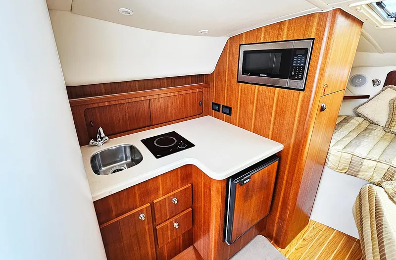 Fidgit Yacht Photos Pics 2006 Tiara Yachts 2900 Open Classic interior with kitchenette, sink, stove, and microwave.