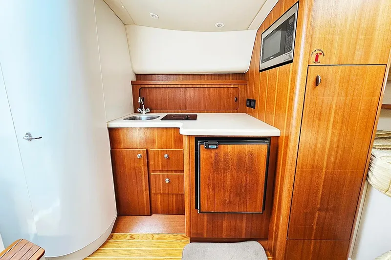 Fidgit Yacht Photos Pics 2006 Tiara Yachts 2900 Open Classic interior with kitchenette, wood cabinetry, and modern appliances.