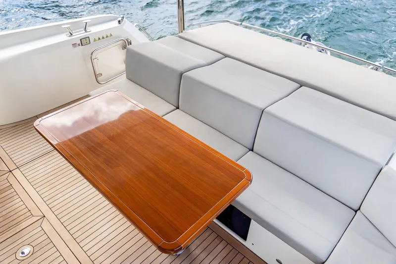 Triangle Yacht Photos Pics Luxurious seating area on 2019 Absolute 58 FLY yacht with wooden table and ocean view.