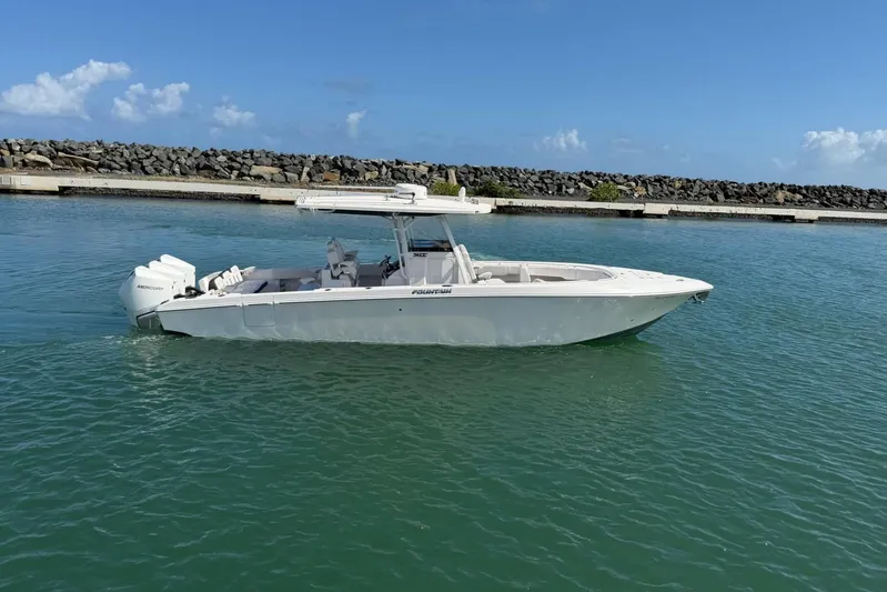  Yacht Photos Pics 2023 Fountain 34 Center Console boat on calm water, clear sky background.