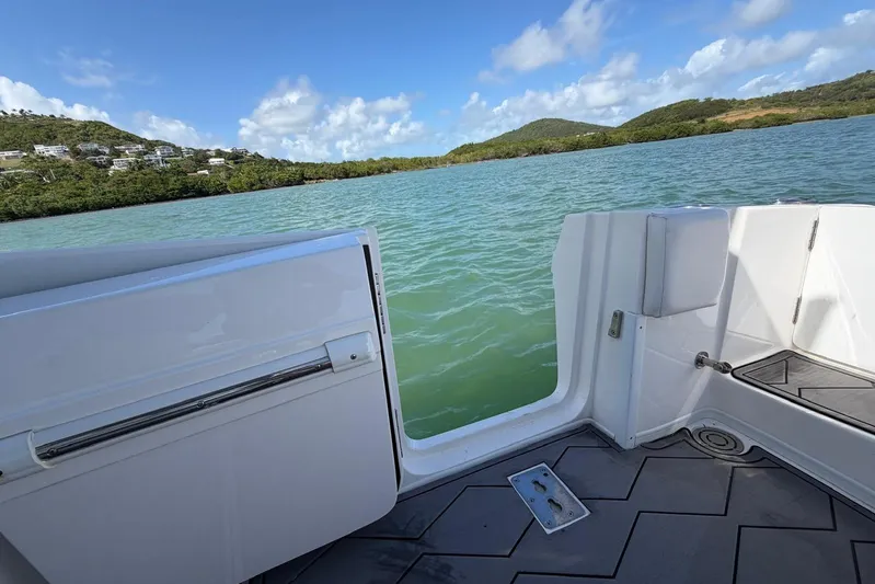  Yacht Photos Pics 2023 Fountain 34 Center Console boat on scenic water with lush green hills.