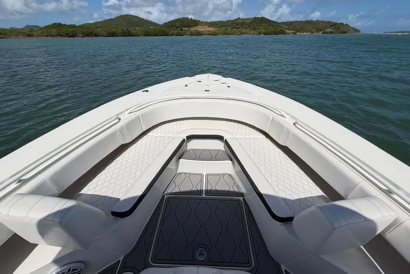  Yacht Photos Pics 2023 Fountain 34 Center Console boat interior with cushioned seating, on calm water.