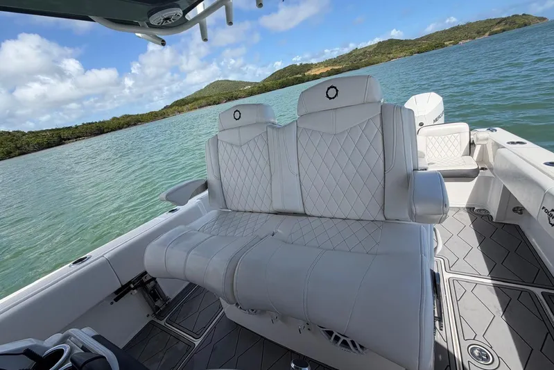  Yacht Photos Pics 2023 Fountain 34 Center Console boat with luxurious white seating on a scenic water backdrop.
