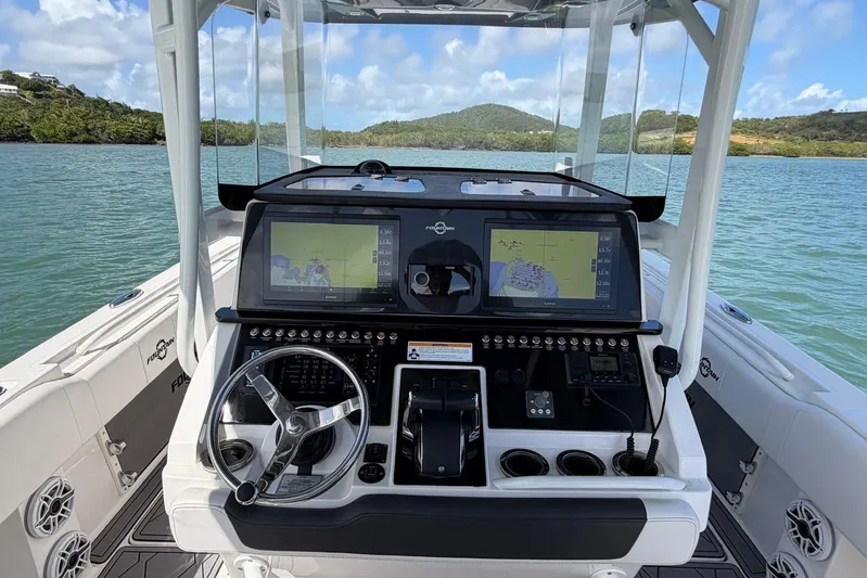  Yacht Photos Pics 2023 Fountain 34 Center Console boat dashboard with navigation screens and steering wheel.