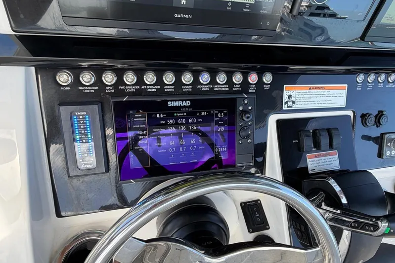  Yacht Photos Pics Control panel of 2023 Fountain 34 Center Console boat with Simrad display and steering wheel.