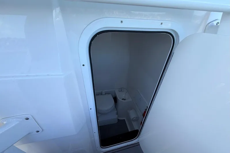  Yacht Photos Pics 2023 Fountain 34 Center Console boat interior with compact marine toilet.