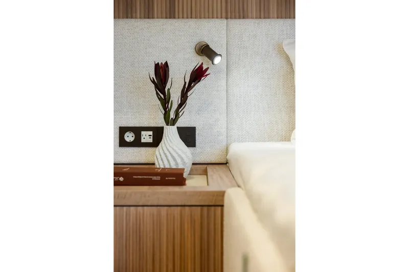 Spice Of Life II Yacht Photos Pics Modern Sunreef 60 yacht interior, featuring a stylish vase, books, and wall-mounted light.