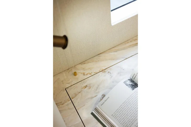 Spice Of Life II Yacht Photos Pics Luxurious interior detail of 2025 Sunreef 60 yacht with marble surface and open book.