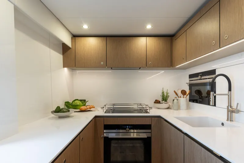 Spice Of Life II Yacht Photos Pics Modern kitchen interior on 2025 Sunreef 60 yacht, featuring sleek cabinetry and appliances.