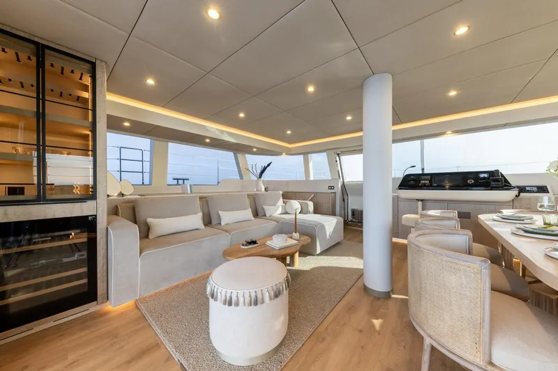 Spice Of Life II Yacht Photos Pics Luxurious interior of 2025 Sunreef 60 yacht with modern furnishings and elegant dining area.
