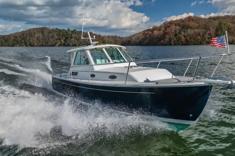  Yacht Photos Pics 2008 Back Cove 29 boat cruising on a scenic lake with American flag.