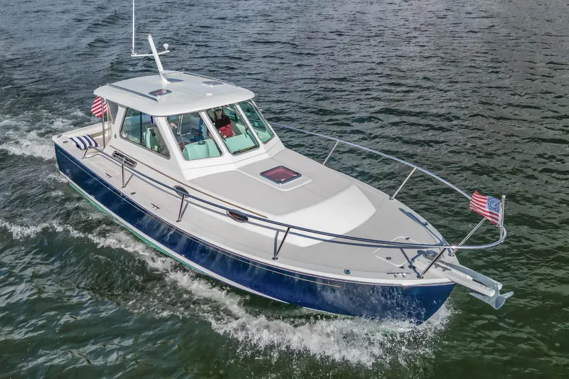  Yacht Photos Pics 2008 Back Cove 29 boat cruising on water with American flags, featuring sleek design and spacious cabin.