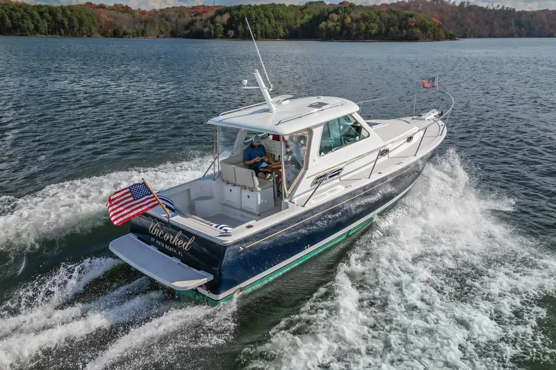  Yacht Photos Pics 2008 Back Cove 29 boat cruising on a lake with American flags.
