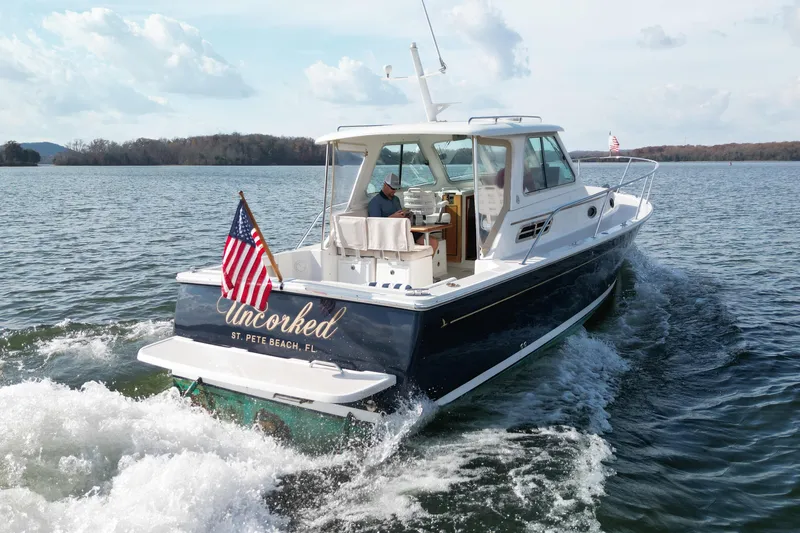  Yacht Photos Pics 2008 Back Cove 29 boat cruising on a lake with American flag, named "Uncorked".