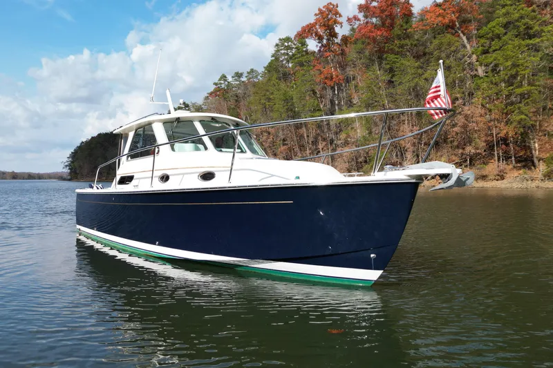  Yacht Photos Pics 2008 Back Cove 29 boat on a serene lake with autumn trees in the background.
