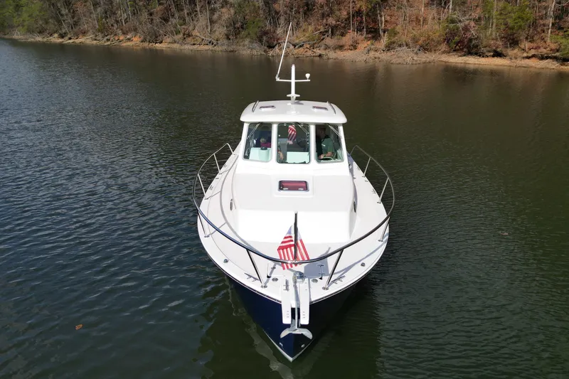 Yacht Photos Pics 2008 Back Cove 29 boat cruising on a calm lake with American flag.
