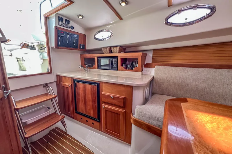  Yacht Photos Pics 2008 Back Cove 29 interior with kitchenette, seating, and wooden cabinetry.