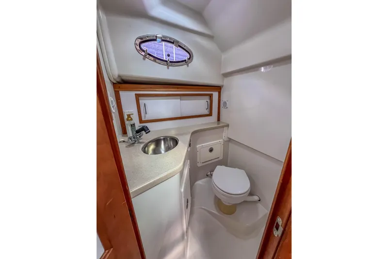  Yacht Photos Pics 2008 Back Cove 29 boat bathroom with sink, toilet, and porthole window.