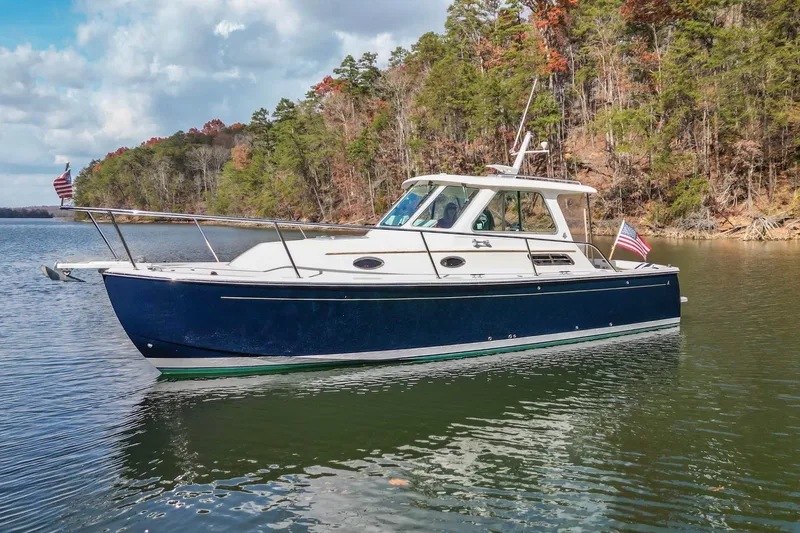  Yacht Photos Pics 2008 Back Cove 29 boat on a serene lake with forested shoreline.