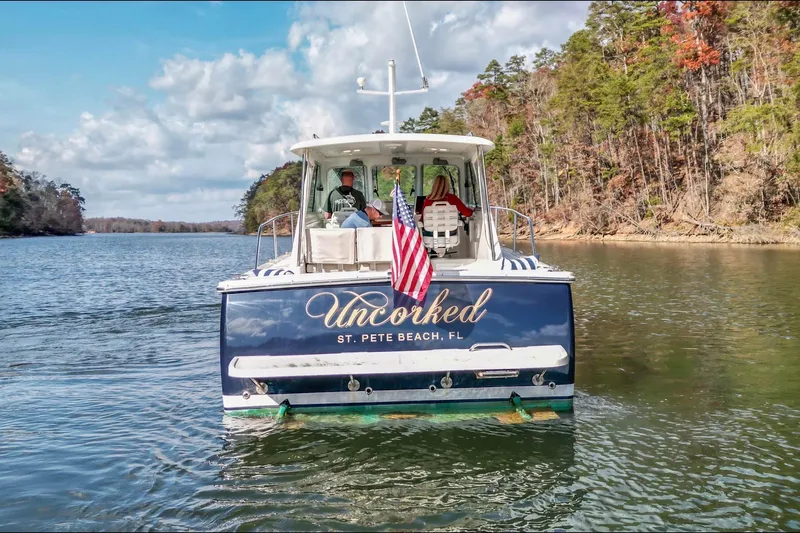  Yacht Photos Pics 2008 Back Cove 29 boat "Uncorked" cruising on a scenic lake with American flag.