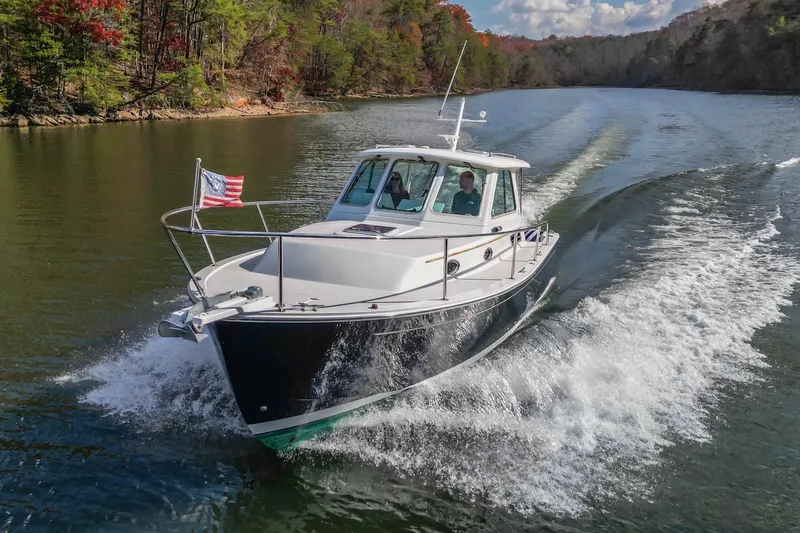  Yacht Photos Pics 2008 Back Cove 29 boat cruising on a scenic river with American flag.