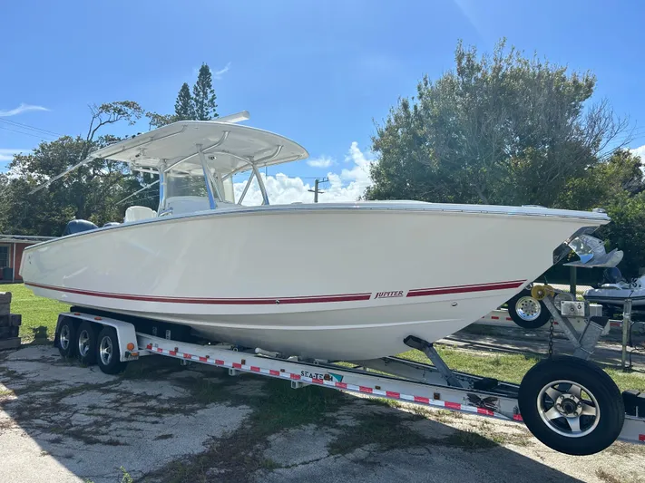  Yacht Photos Pics 2013 Jupiter 34 boat on trailer, parked outdoors under clear blue sky.