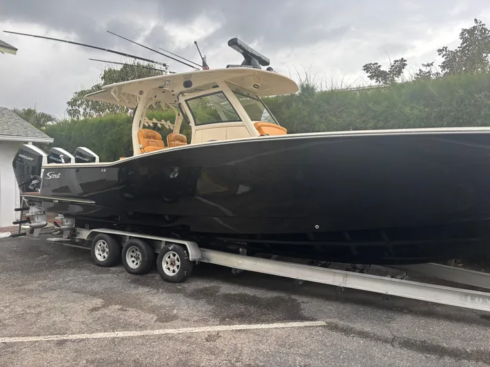  Yacht Photos Pics 2014 Scout 350 LXF boat on trailer, black hull, parked outdoors.