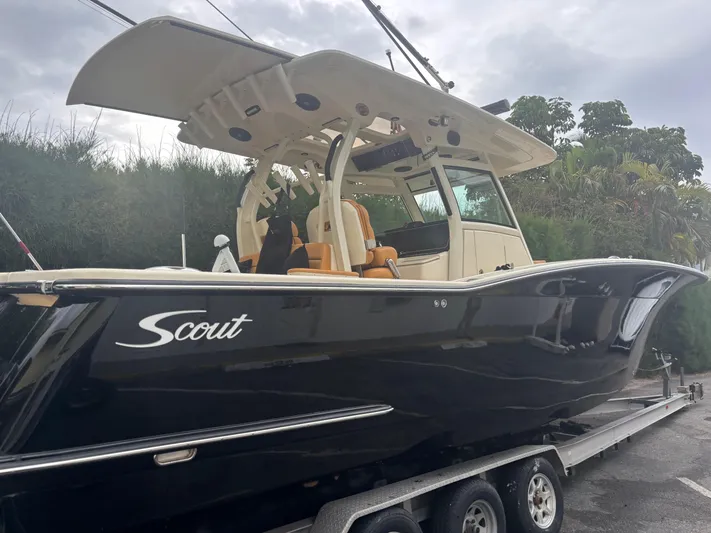  Yacht Photos Pics 2014 Scout 350 LXF boat on trailer, black hull, outdoor setting.