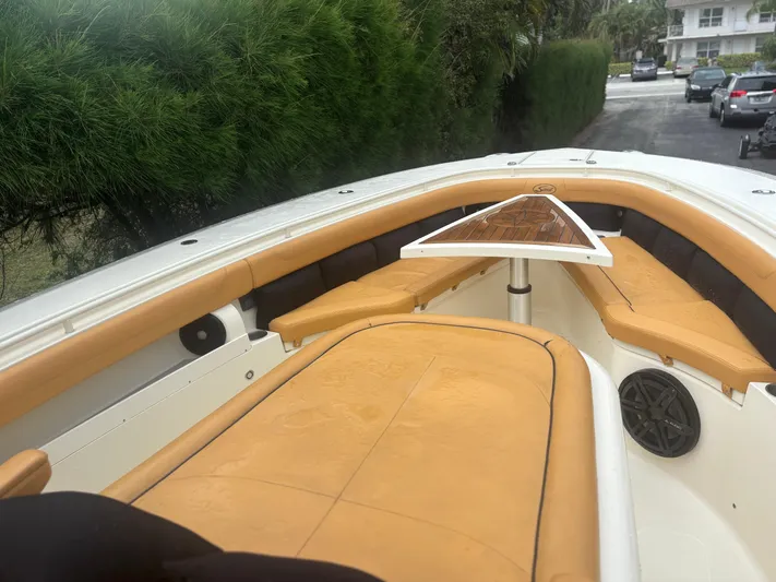 Yacht Photos Pics 2014 Scout 350 LXF boat interior with tan seating and table, parked outdoors.