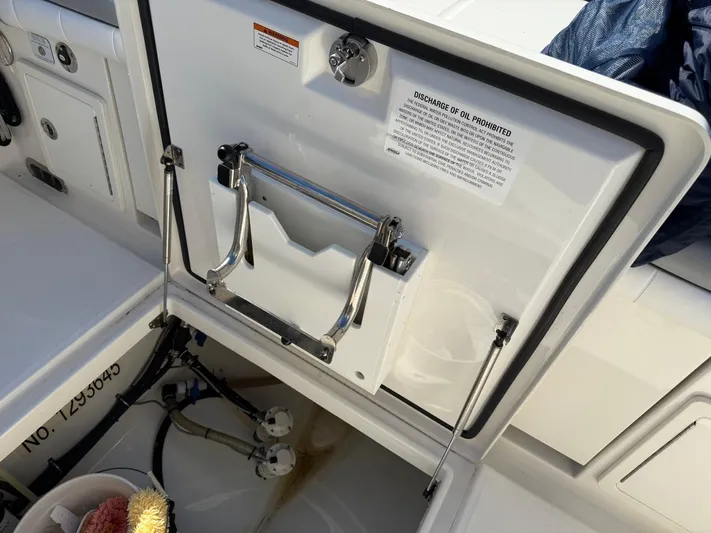 Deadicated Yacht Photos Pics 2019 Regulator 31 boat storage compartment with open hatch and safety notice.