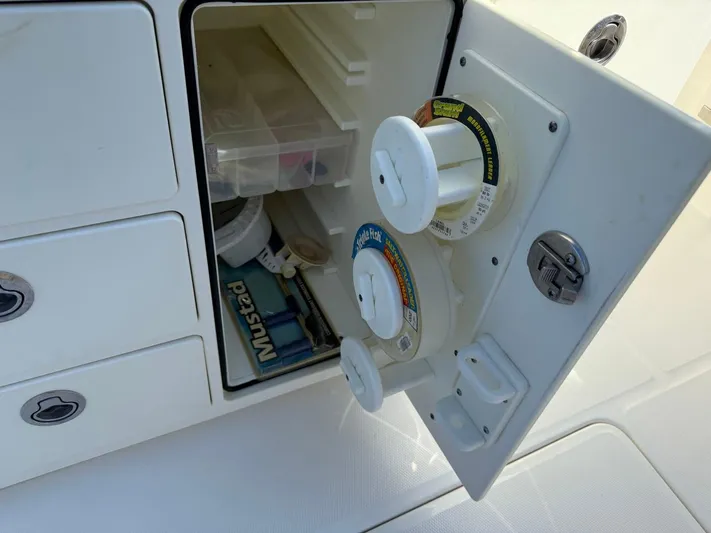 Deadicated Yacht Photos Pics 2019 Regulator 31 boat storage compartment with fishing line spools and tackle box.