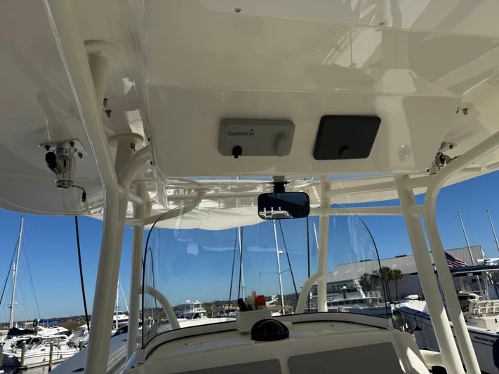 Deadicated Yacht Photos Pics 2019 Regulator 31 boat interior with Garmin equipment, docked at a marina under clear blue sky.